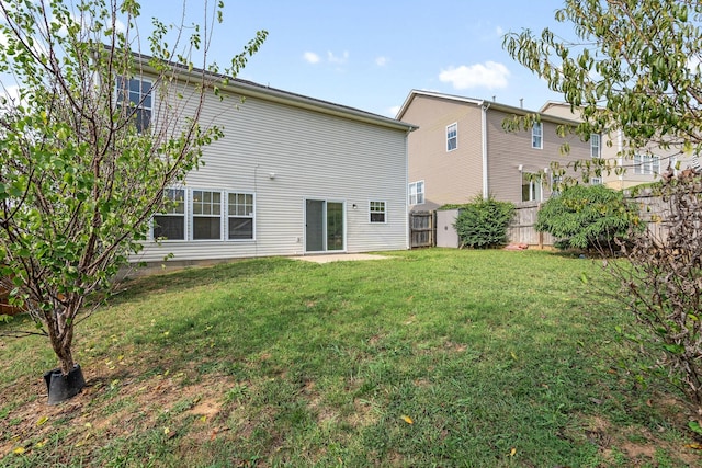 rear view of property featuring a lawn