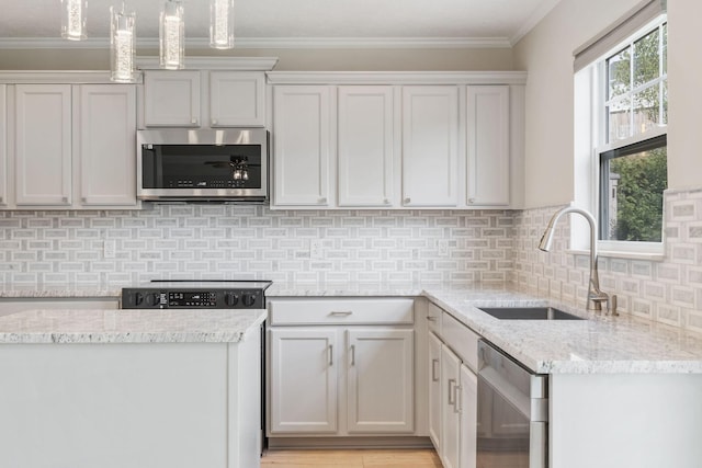 kitchen featuring sink, tasteful backsplash, ornamental molding, appliances with stainless steel finishes, and light stone countertops