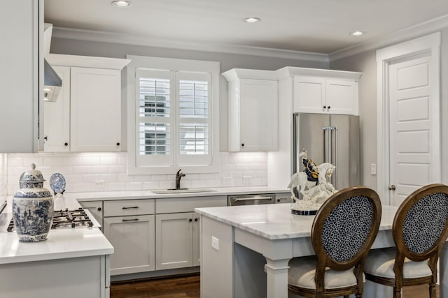 kitchen with white cabinetry, appliances with stainless steel finishes, sink, and a kitchen island