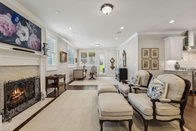 living room featuring crown molding, a fireplace, and light hardwood / wood-style floors