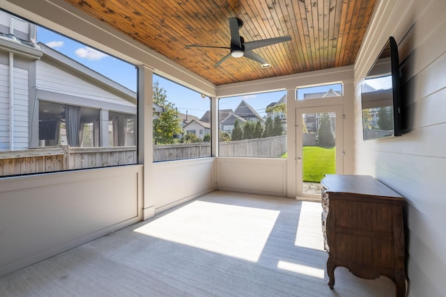 unfurnished sunroom with wood ceiling, a wealth of natural light, and ceiling fan