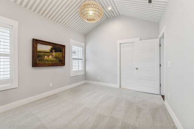 unfurnished bedroom featuring light colored carpet and lofted ceiling