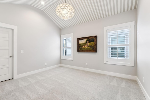 carpeted empty room featuring lofted ceiling