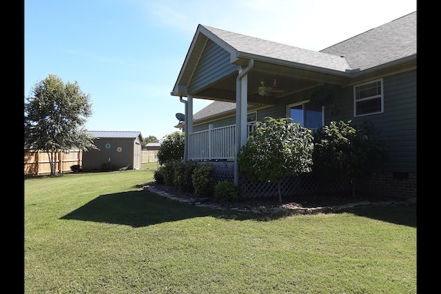 view of yard featuring ceiling fan and a shed