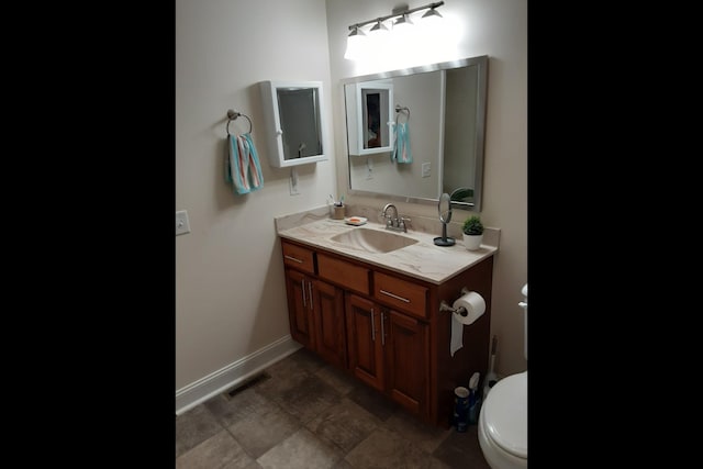 bathroom featuring vanity and toilet