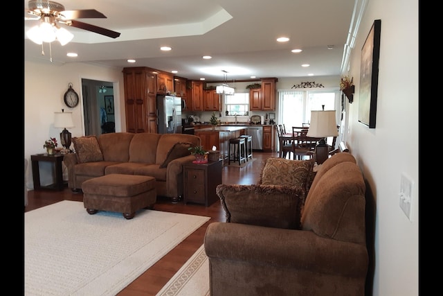 living room featuring dark wood-type flooring and ceiling fan