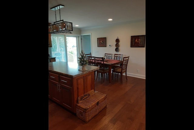 kitchen featuring hanging light fixtures, crown molding, dark wood-type flooring, and light stone countertops