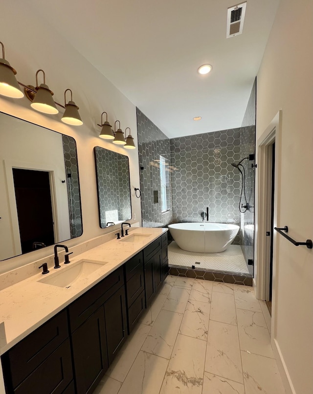 bathroom featuring vanity and independent shower and bath