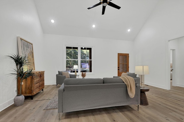 living room featuring ceiling fan, high vaulted ceiling, and light hardwood / wood-style flooring