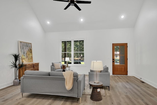 living room featuring ceiling fan, high vaulted ceiling, and light hardwood / wood-style floors