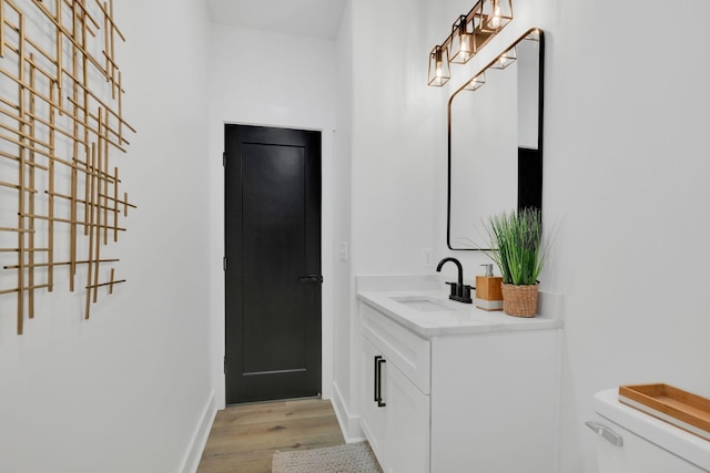 bathroom with vanity, wood-type flooring, and toilet