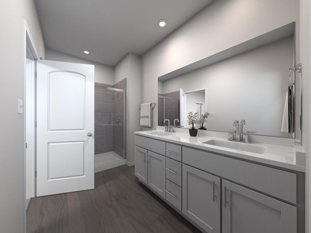 bathroom featuring hardwood / wood-style flooring, tiled shower, and vanity