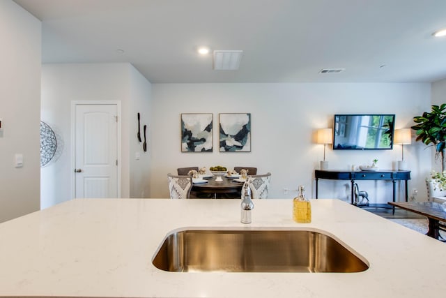 kitchen featuring sink and light stone counters