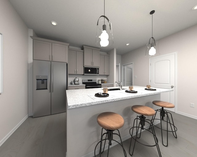 kitchen featuring gray cabinets, an island with sink, appliances with stainless steel finishes, and pendant lighting