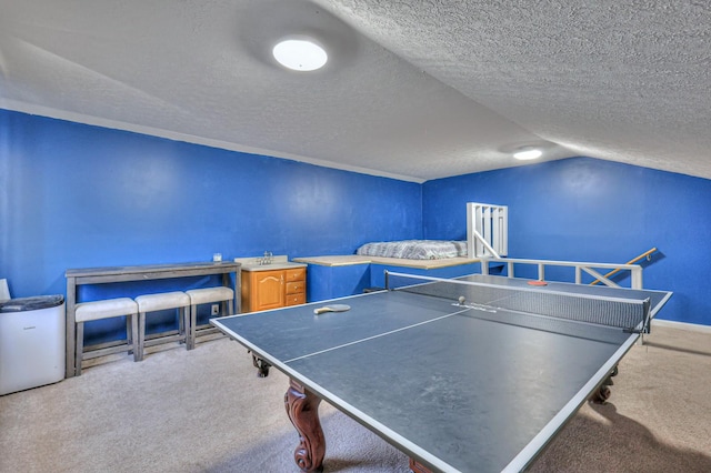 recreation room featuring vaulted ceiling, carpet flooring, sink, and a textured ceiling