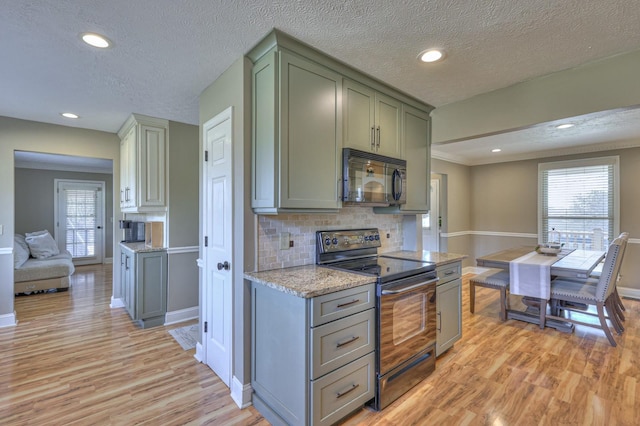 kitchen featuring decorative backsplash, light hardwood / wood-style flooring, stainless steel range with electric cooktop, and a wealth of natural light