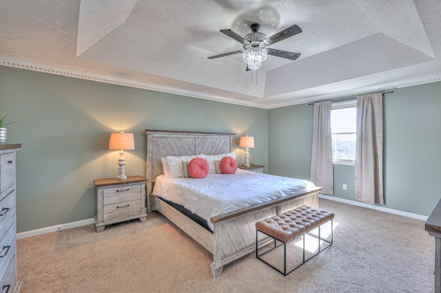 bedroom featuring ceiling fan, light colored carpet, a raised ceiling, and a textured ceiling