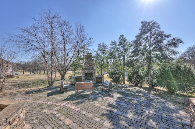 view of patio featuring an outdoor stone fireplace