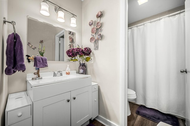 bathroom with hardwood / wood-style flooring, vanity, and toilet