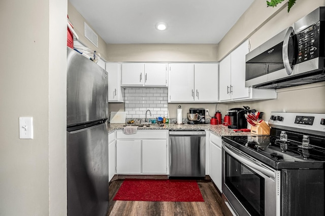 kitchen with sink, tasteful backsplash, appliances with stainless steel finishes, dark hardwood / wood-style flooring, and white cabinets