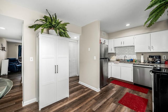 kitchen featuring dark wood-type flooring, sink, white cabinetry, stainless steel appliances, and backsplash