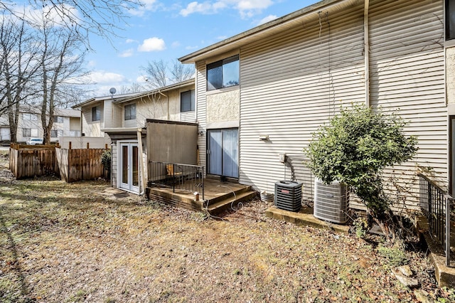 rear view of house featuring cooling unit and a wooden deck