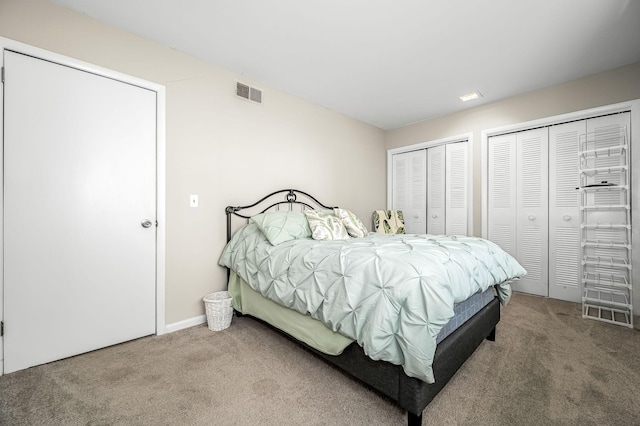 carpeted bedroom featuring multiple closets