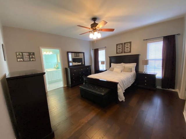 bedroom featuring dark hardwood / wood-style flooring, ensuite bath, and ceiling fan