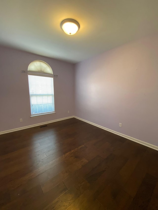 unfurnished room featuring dark wood-type flooring