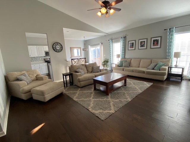 living room featuring vaulted ceiling, plenty of natural light, ceiling fan, and dark hardwood / wood-style flooring