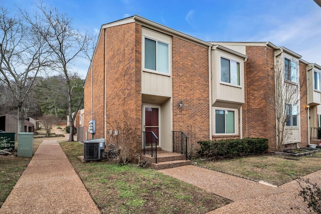 view of front of property with central AC unit and a front lawn