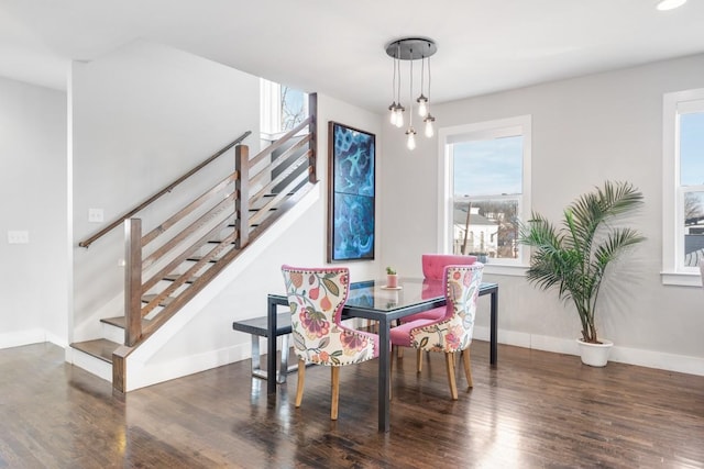 dining space with dark wood-type flooring and a notable chandelier