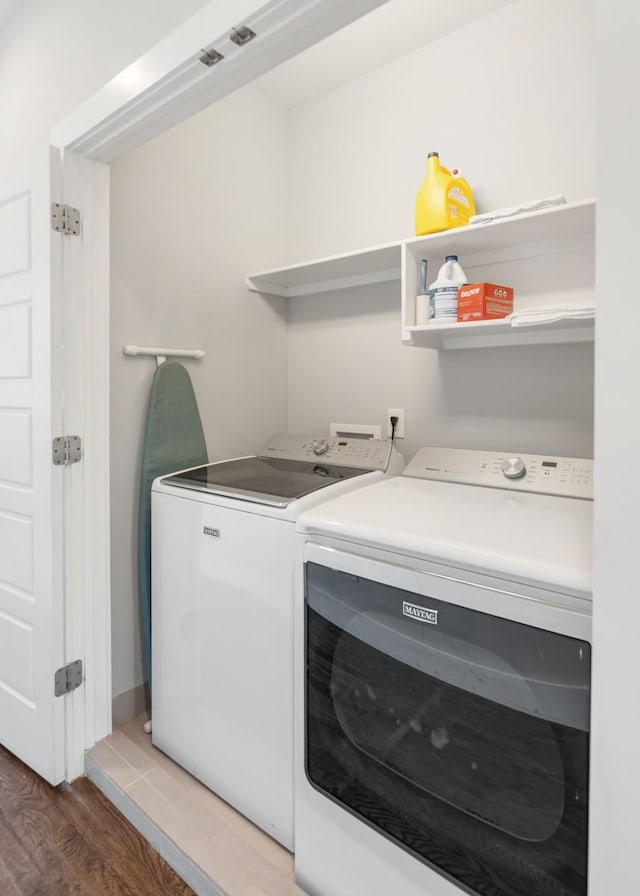 washroom featuring hardwood / wood-style flooring and washing machine and clothes dryer