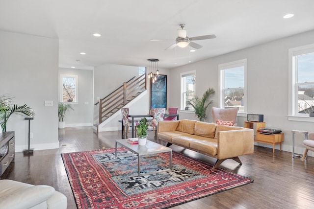 living room with dark wood-type flooring, a wealth of natural light, and ceiling fan