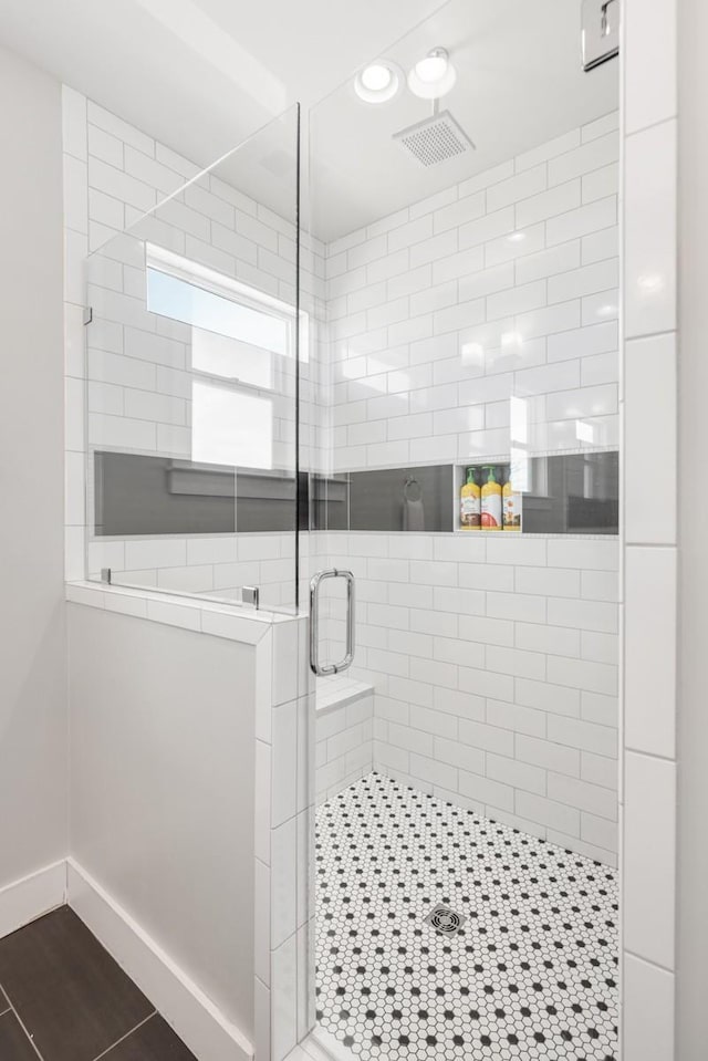 bathroom featuring wood-type flooring and a shower with shower door