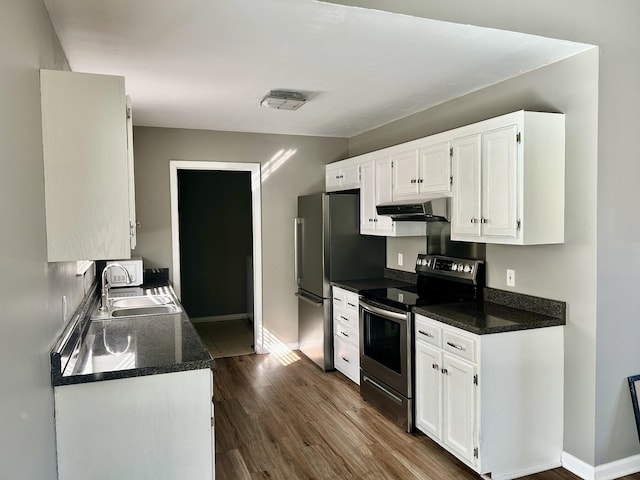 kitchen with appliances with stainless steel finishes, sink, white cabinets, and dark hardwood / wood-style floors