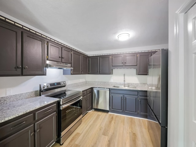 kitchen featuring dark brown cabinetry, sink, light hardwood / wood-style flooring, and stainless steel appliances