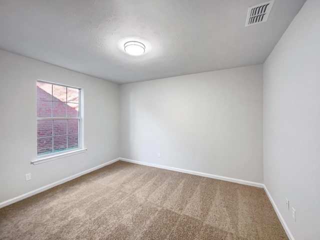 carpeted spare room featuring a textured ceiling