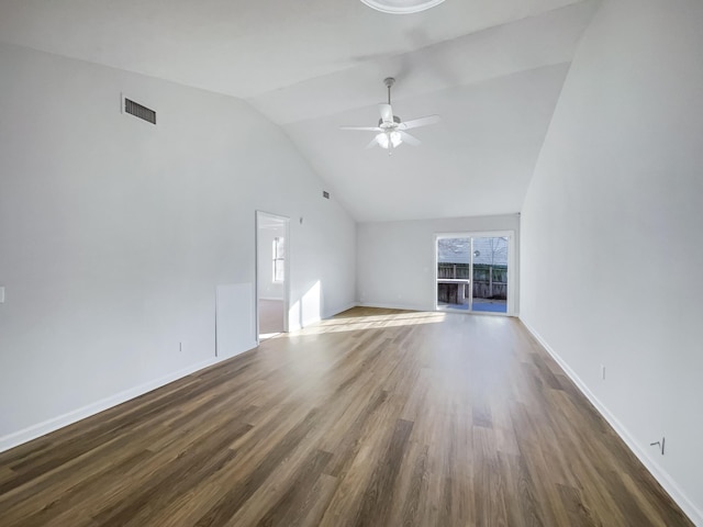 unfurnished living room featuring vaulted ceiling, dark wood-type flooring, a wealth of natural light, and ceiling fan