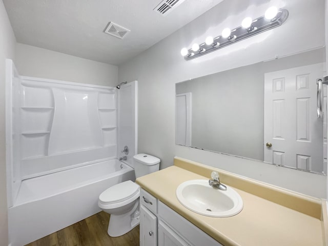 full bathroom featuring vanity, hardwood / wood-style floors, shower / tub combination, and toilet