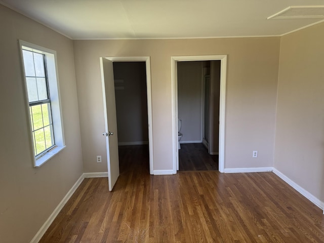 unfurnished bedroom with dark wood-style floors, baseboards, and ornamental molding