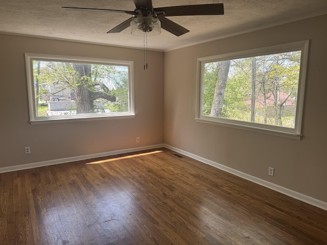 empty room with a wealth of natural light, ceiling fan, a textured ceiling, and wood finished floors