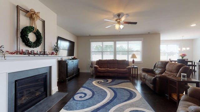 living room featuring ceiling fan with notable chandelier and dark hardwood / wood-style floors