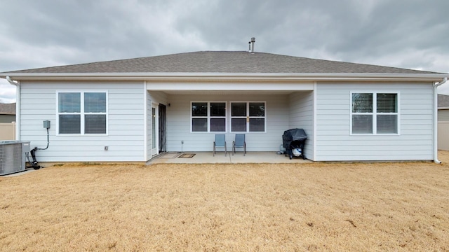 rear view of house with a patio, a yard, and central AC