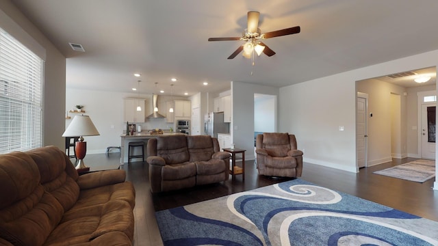 living room featuring ceiling fan and dark hardwood / wood-style floors