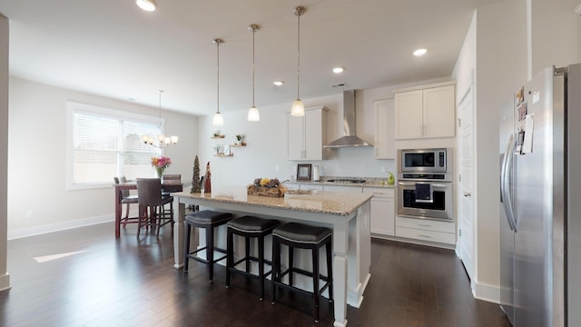 kitchen featuring white cabinetry, wall chimney range hood, a kitchen island with sink, and stainless steel appliances