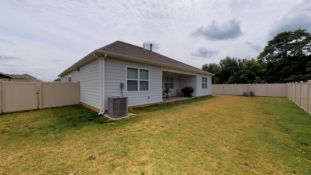 rear view of property with central AC, a patio, and a lawn