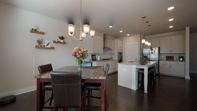 dining space featuring dark wood-type flooring, sink, and a notable chandelier