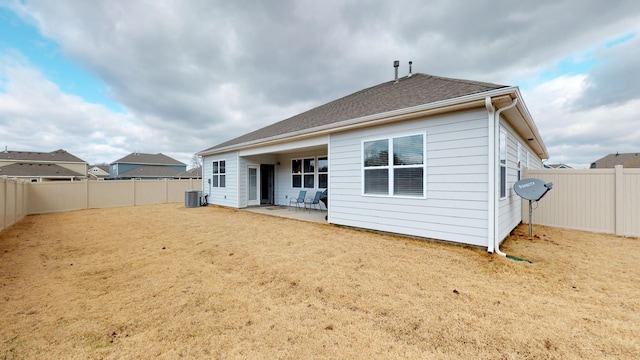 rear view of house with a yard, central AC, and a patio