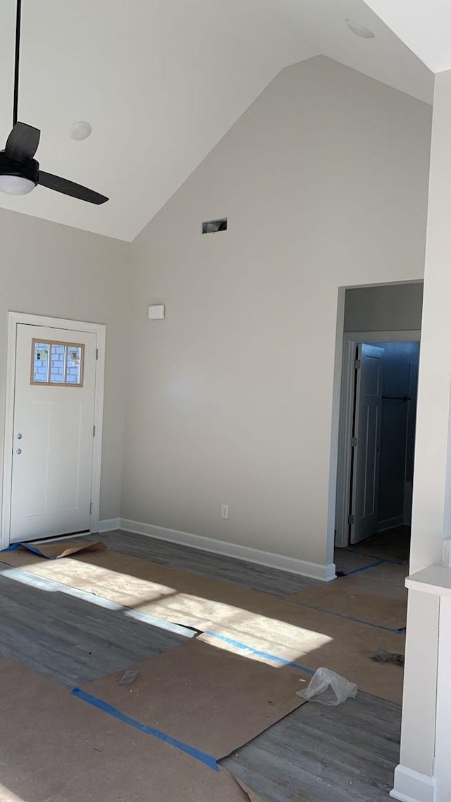 interior space featuring high vaulted ceiling, a ceiling fan, and baseboards